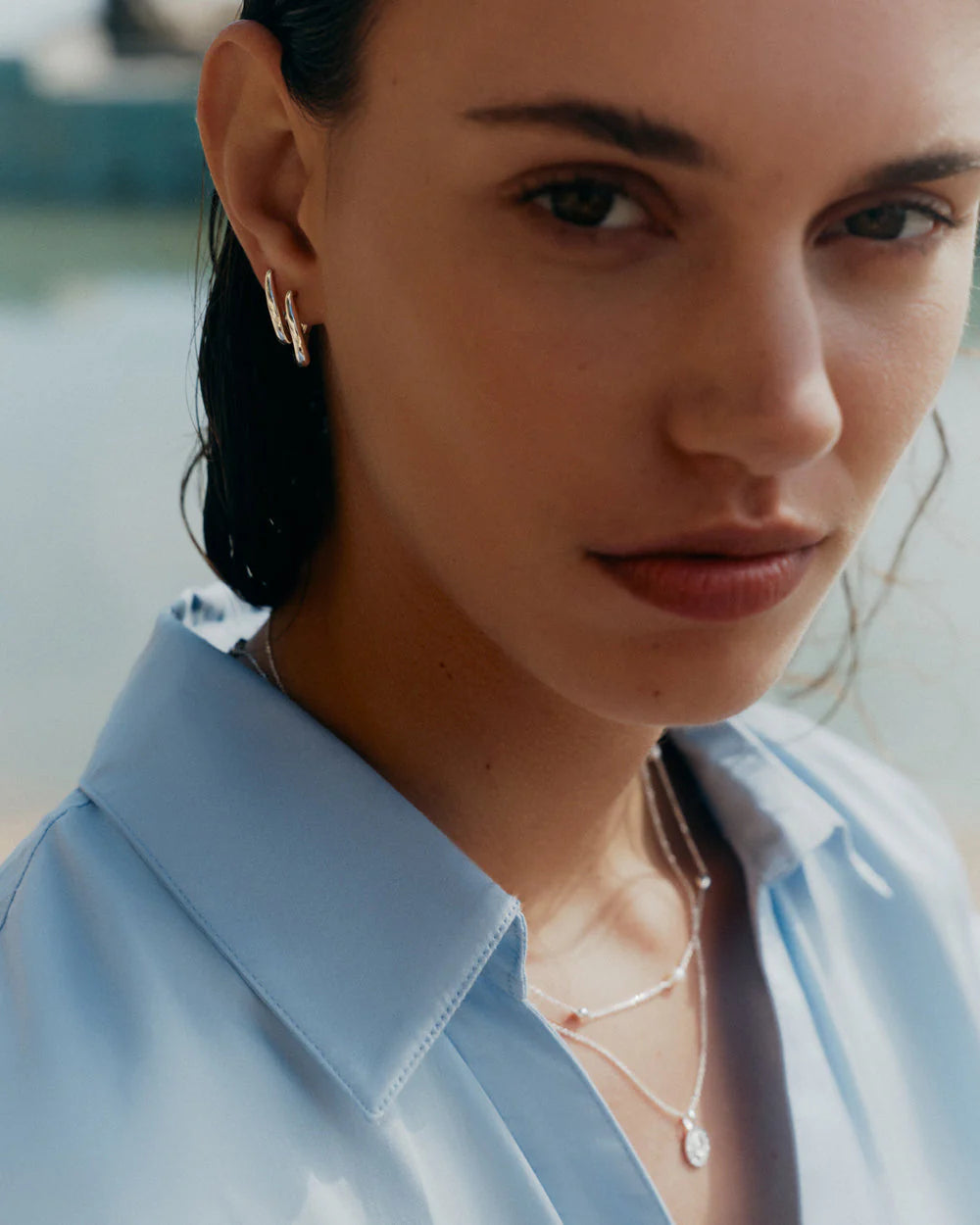 Close-up of a woman wearing a light blue shirt with a blurred background