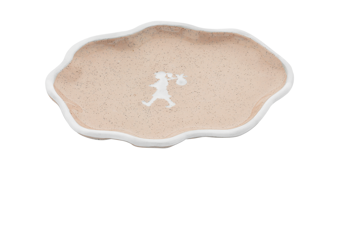 Decorative plate with a white silhouette design on a beige background